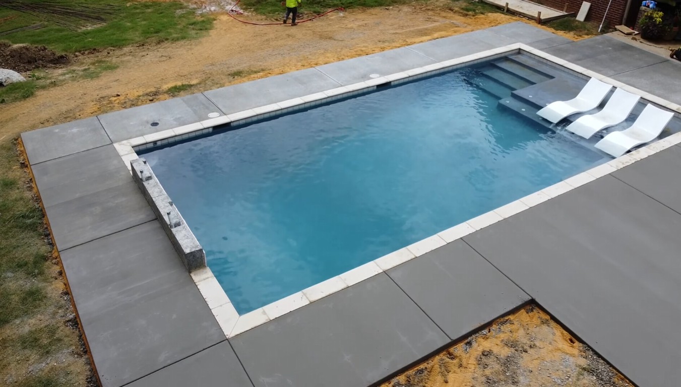 Freshly installed gray concrete pool deck surrounding a residential swimming pool in Santa Rosa, CA